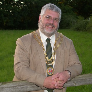 Mayor leaning on fence